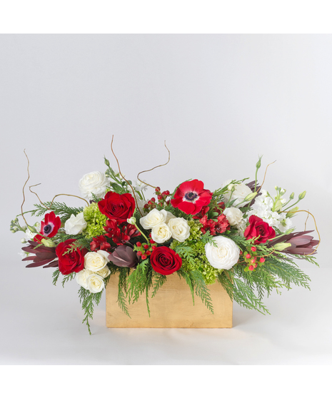Celebrate the season in style with our Deck the Halls Centerpiece, a festive design arranged in an elegant gold rectangle vase. 
