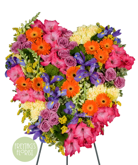 Sympathy heart designed with a mix of bright assorted flowers. 