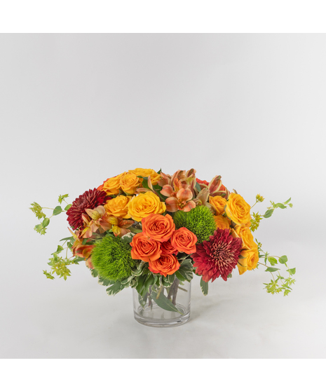 Fall Horizon is a warm and inviting autumn design presented in a clear glass vase.