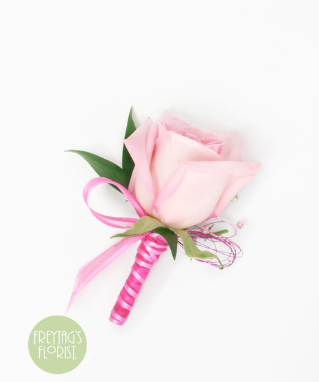 This simple rose boutonniere includes a rose bloom, Italian Ruscus green accents, and pink ribbon.