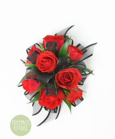 You can never go wrong with a simple spray rose corsage with rose blooms, Italian Ruscus green accents, and black ribbon.