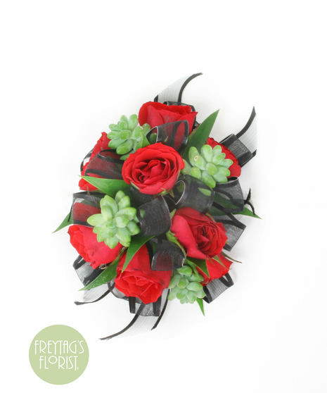 You can never go wrong with a simple spray rose corsage with rose blooms, Italian Ruscus green accents, and black ribbon.